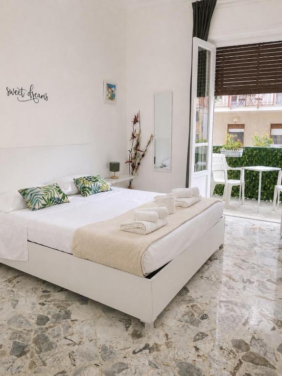 a white bedroom with a large white bed with pillows at Pellegrino House in Palermo