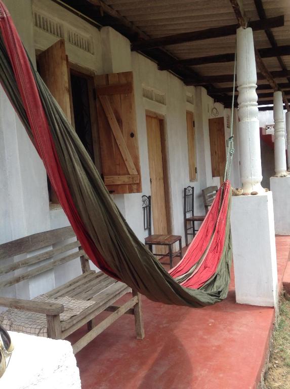 a porch with a hammock and a bench in a house at Cafe Nilaveli in Nilaveli