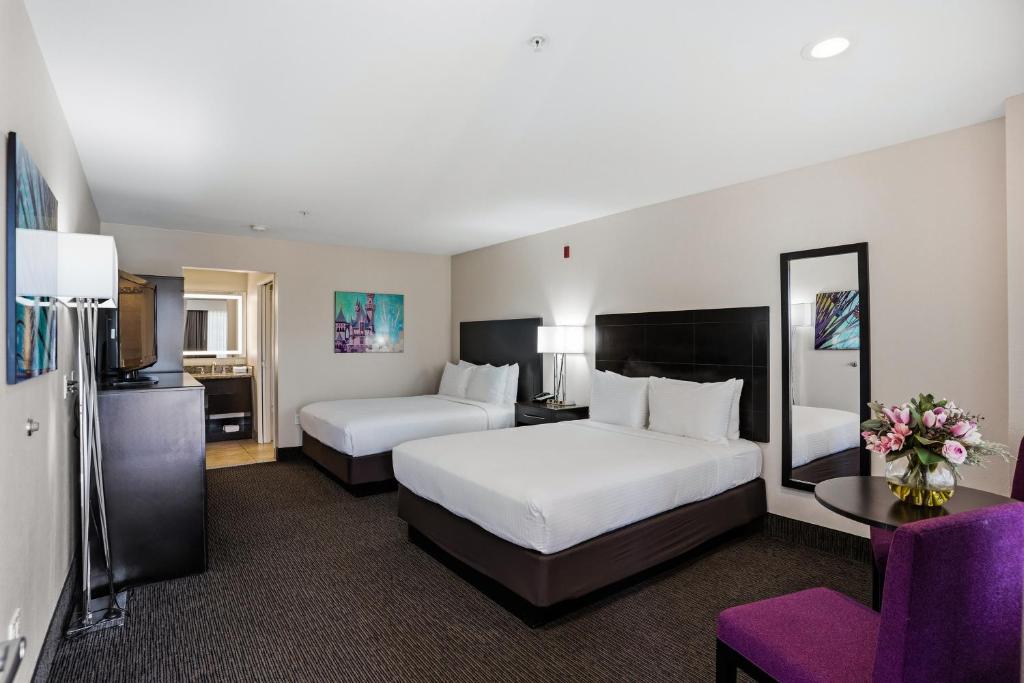 a hotel room with two beds and a purple chair at Grand Legacy At The Park in Anaheim