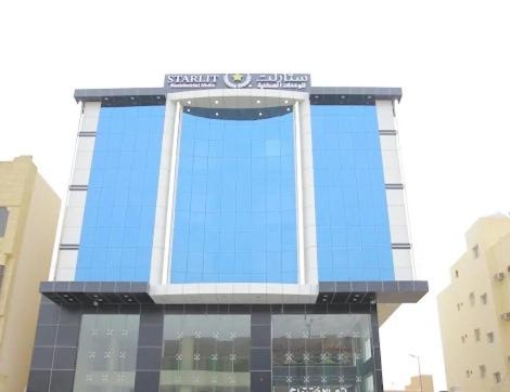 a tall building with a blue glass facade at ستارلت للشقق المخدومة in Buraydah