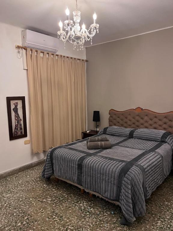 a bedroom with a bed and a chandelier at Lomar Apart 2 - Depto céntrico Villa María in Villa María