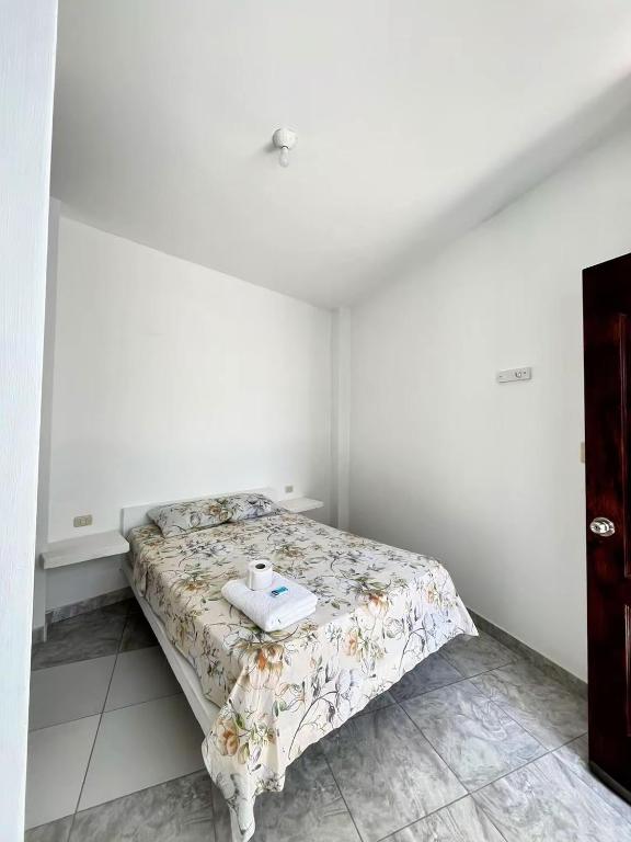 a white bedroom with a bed with a tray on it at Hospedaje Dora in Máncora
