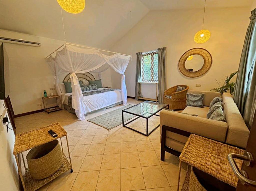 a living room with a couch and a bed at Palm Villa Hideaway in Diani Beach