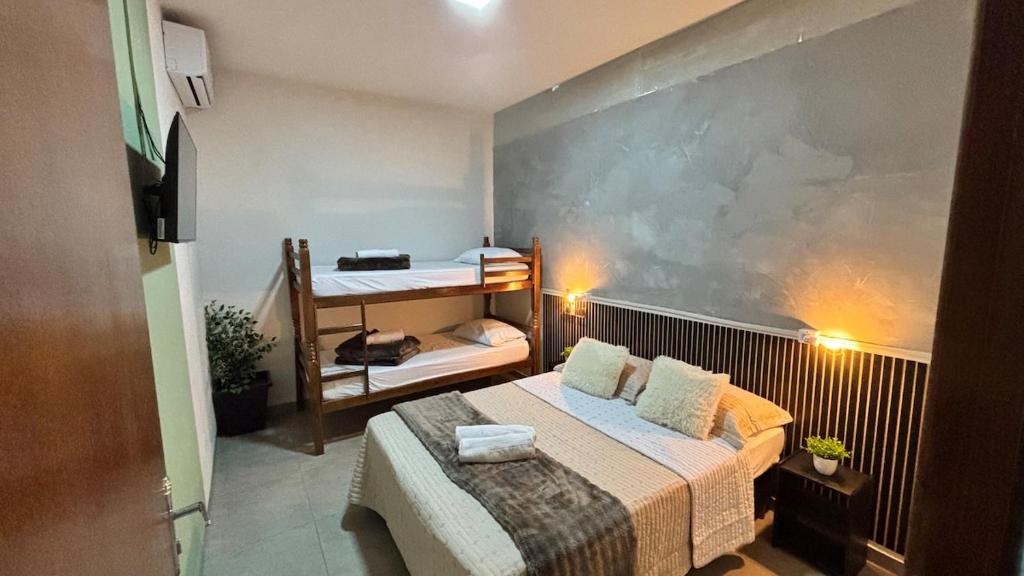 a small room with a bed and a bunk bed at Apto 05 - A&N Estadia Premium - Centro Bandeirantes PR in Bandeirantes