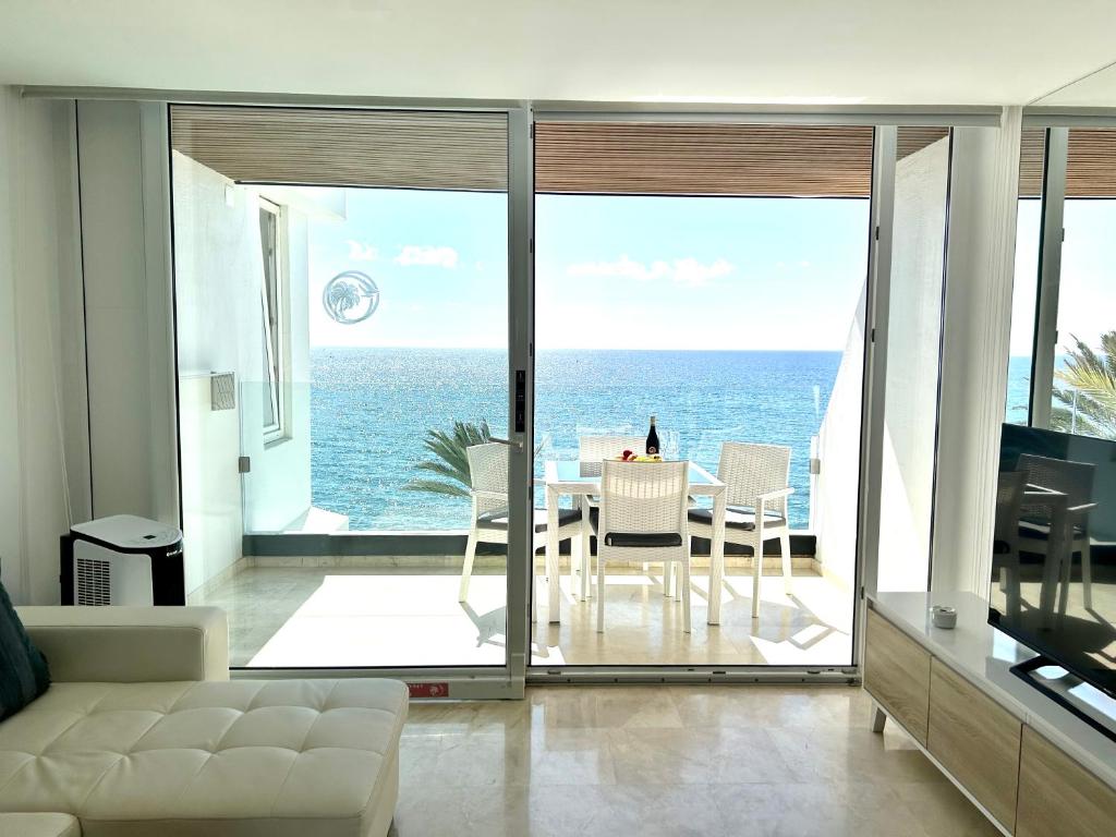 a living room with a view of the ocean at Sunset Ocean Oceanvrent in Arguineguín