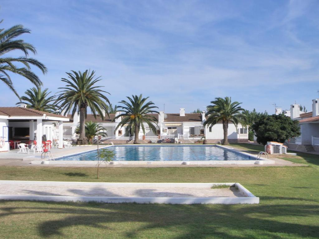 uma piscina num quintal com palmeiras em Allotjament Joana em Riumar