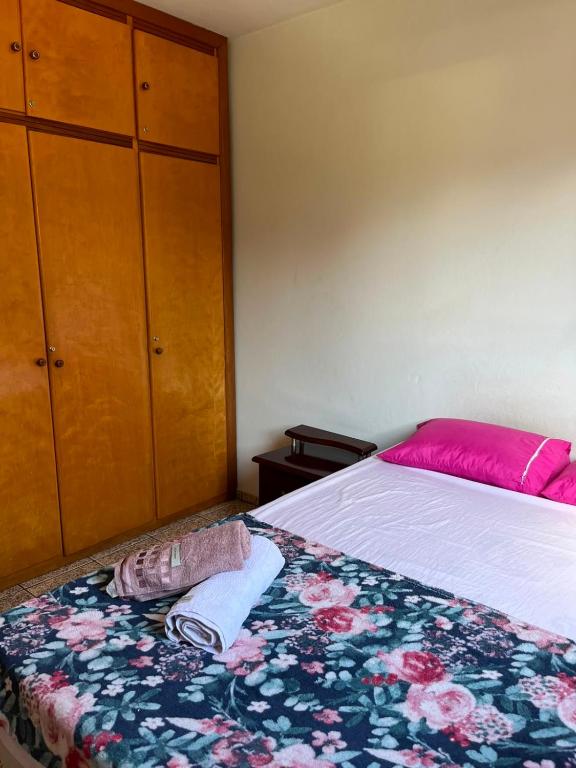 a bedroom with a bed and a dresser at Apartamento simples no centro de Lavras com garagem in Lavras