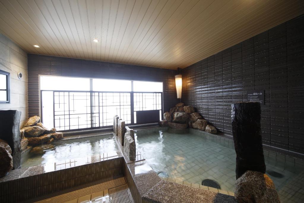 a large swimming pool in a large room with at Dormy Inn Miyazaki Natural Hot Spring in Miyazaki