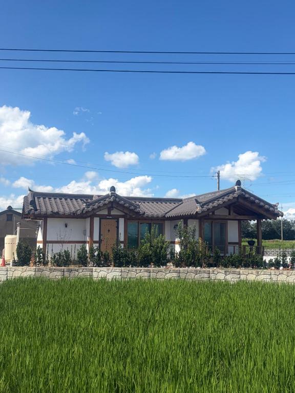 a house with a green field in front of it at 시골마을 한옥독채 '가니재' in Ssangjŏng-ni