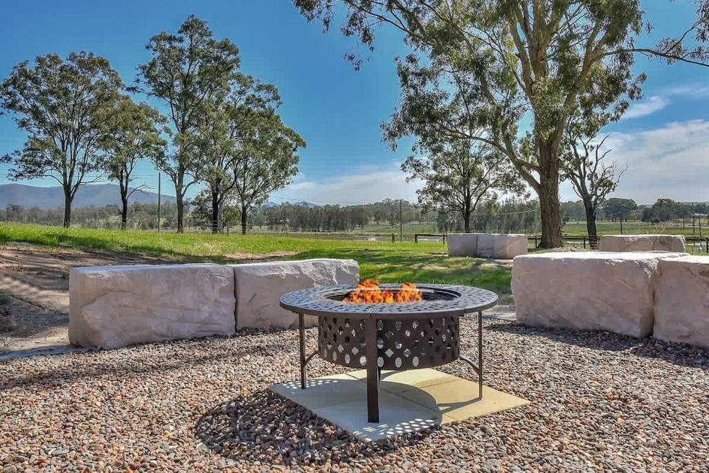a table with a fire pit in a park at Andres Farm Cottage in Broke
