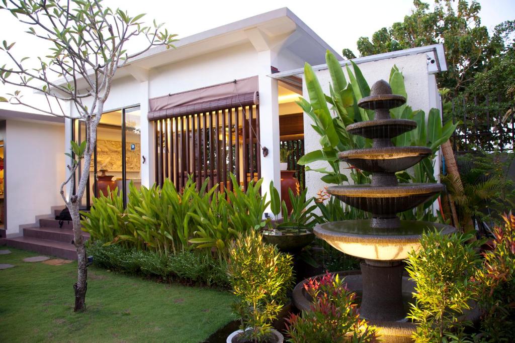 una fuente frente a una casa con plantas en Muaya Villa en Jimbaran