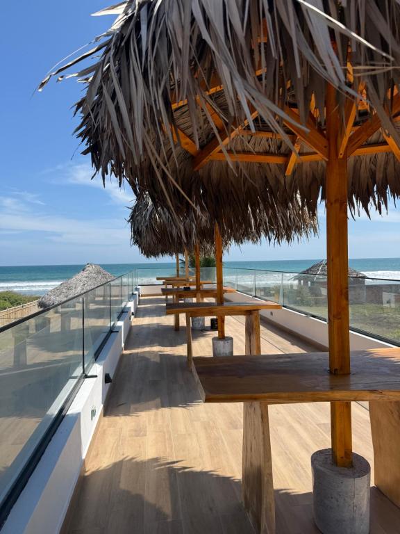a row of benches with the ocean in the background at Helite Arena y Mar in Puerto Cayo