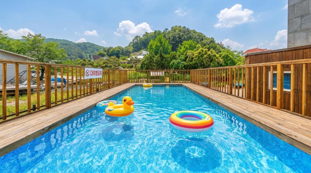 a swimming pool with two rubber ducks and a raft at Gapyeong Rialto Pension in Gapyeong