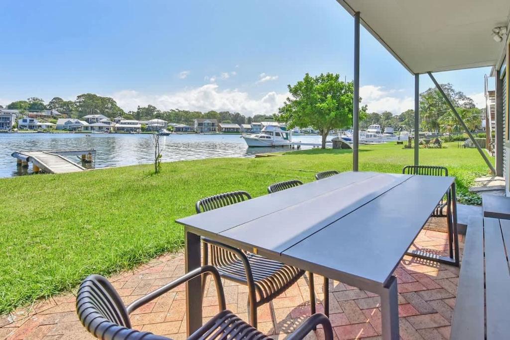 a table and chairs with a view of the water at Balmoral Waterfront Escape at Lake Macquarie in Balmoral