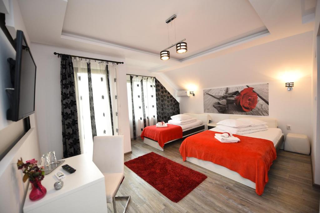 ハツェグにあるCasa Avyのベッド2台とテレビが備わるホテルルームです。