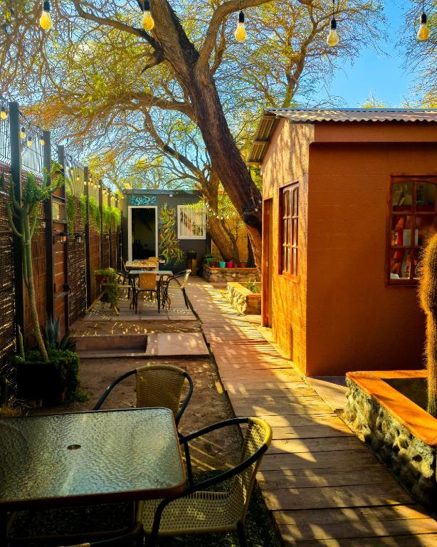 a patio with a table and chairs and a building at Hostal Perita in San Pedro de Atacama