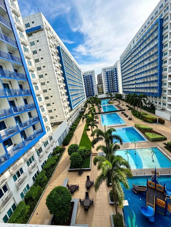 an aerial view of a resort with a pool and palm trees at Sea Residences Sunset Point in Manila