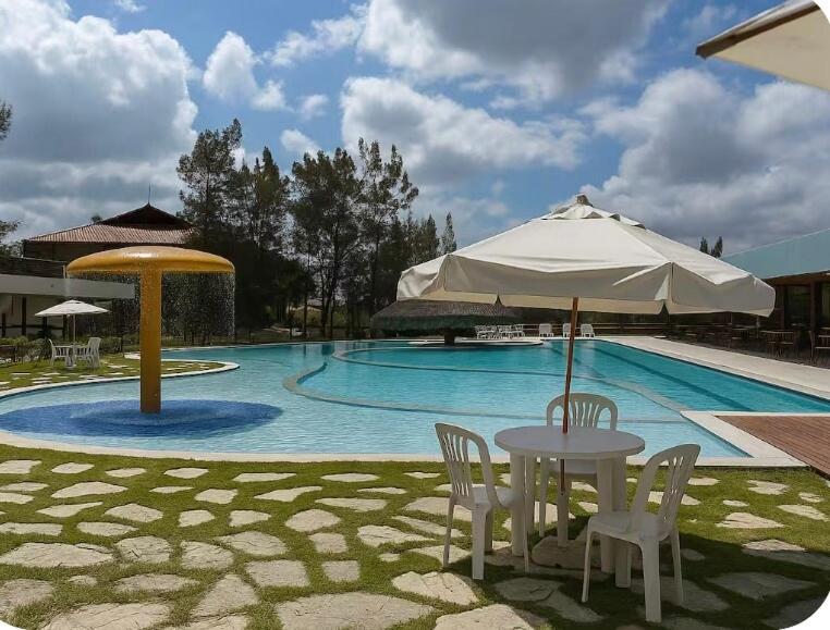 a table with an umbrella next to a swimming pool at Luxury flat in Monte Castelo in Sairé