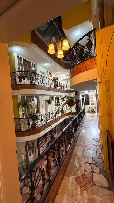 a hallway of a building with balconies and plants at Hostal kimbala in Cotacachi