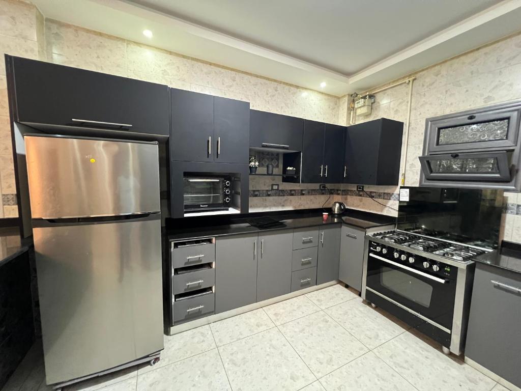 a kitchen with black and stainless steel appliances at شقه بڤيلا in Madīnat as Sādāt