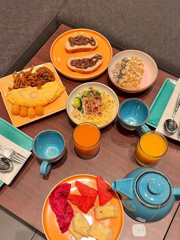 A styled breakfast spread with hot dishes, fruit, drinks, and tea.