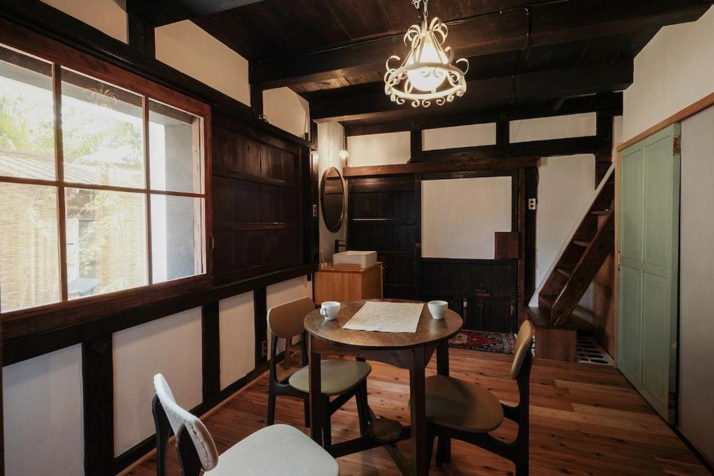 a dining room with a table and chairs and a chandelier at 眠ル庭ーnemuruniwa in Tochigi
