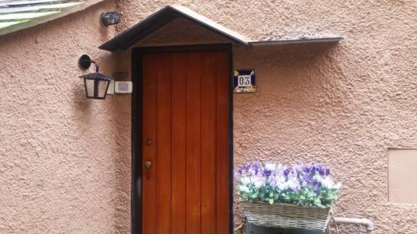 a house with a wooden door and a window and flowers at Civico 3 in Portofino