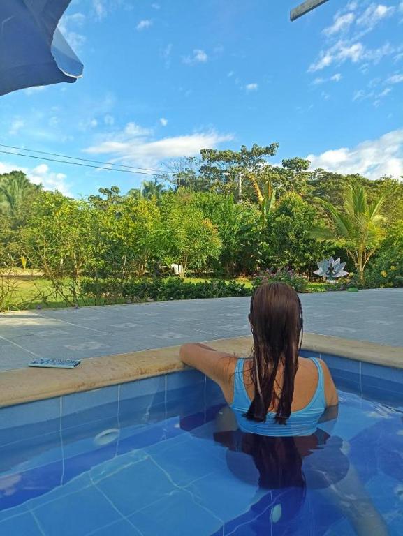 a woman sitting in the water in a swimming pool at Maná Quinta Campestre in Carmen de Apicalá