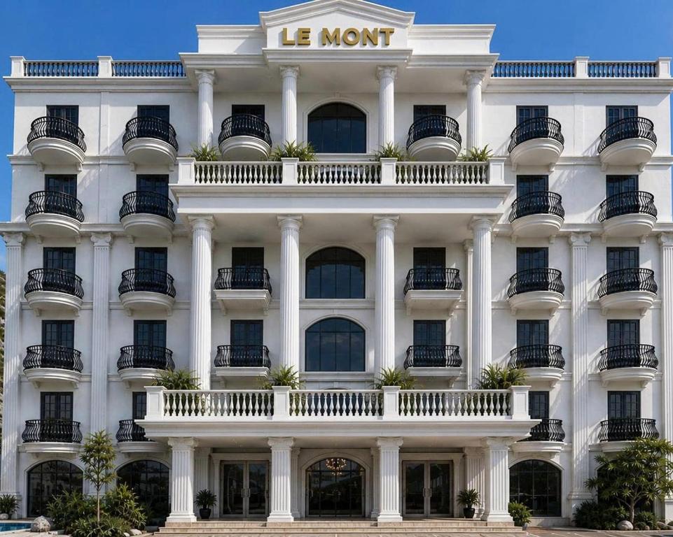a white building with a sign on it at Le Mont Yên Bái in Yên Bái