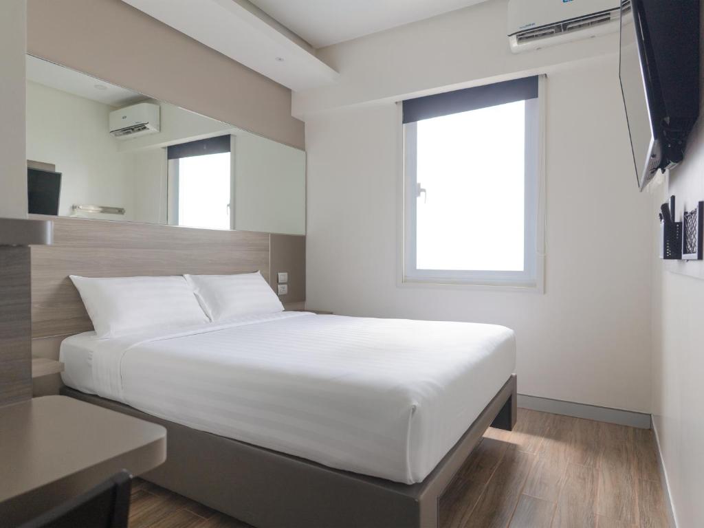 a bedroom with a large white bed and a window at Red Planet Manila Binondo in Manila