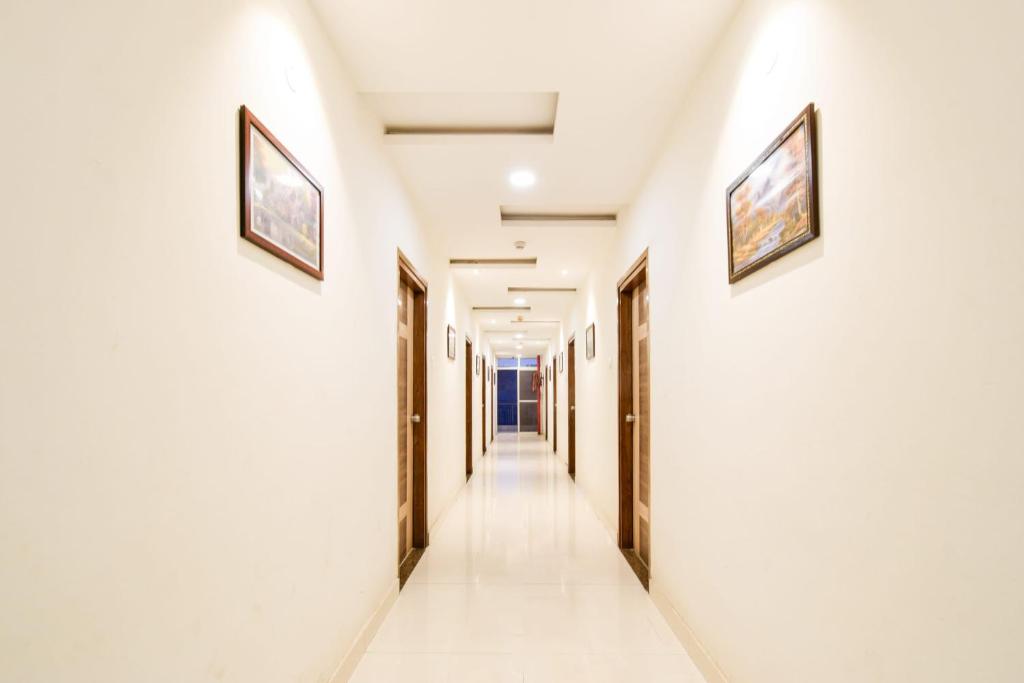 a corridor in a building with two pictures on the walls at Super Townhouse Raniganj Formerly Devi Residency in Hyderabad