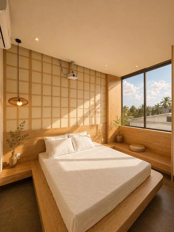 a bedroom with a large bed and a large window at Shine Home in Diẻn Pha Phương