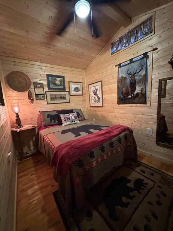a bedroom with a bed in a log cabin at Little Bear Tiny Cabin in Cosby