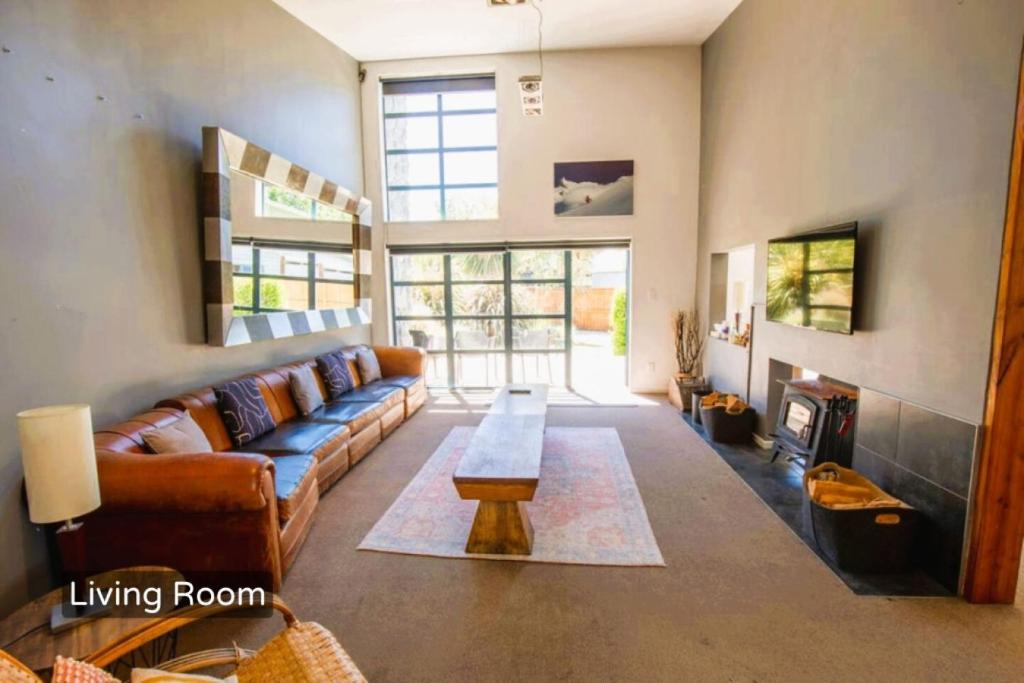 a living room with a couch and a table at Spacious Mt Hutt Ski & Summer Lodge in Methven with Spa in Methven