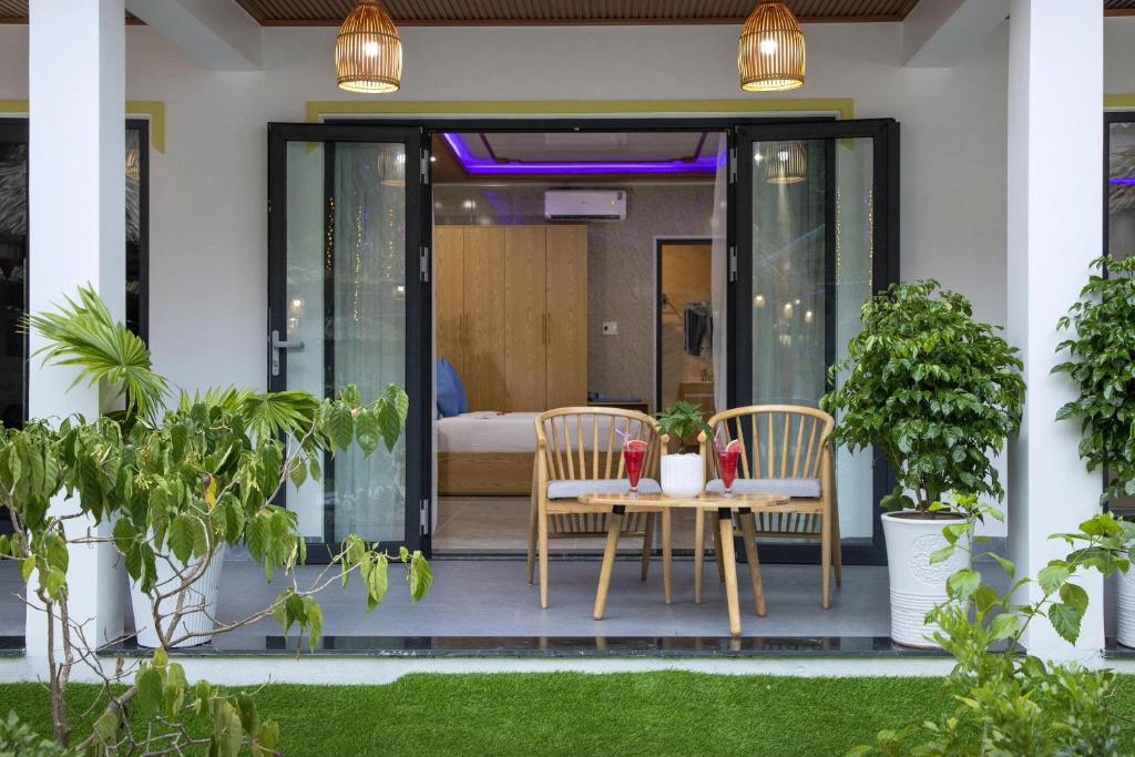 a patio with a table and chairs in a house at Hoi An Ocean Waves Homestay in Hà My Tây (2)