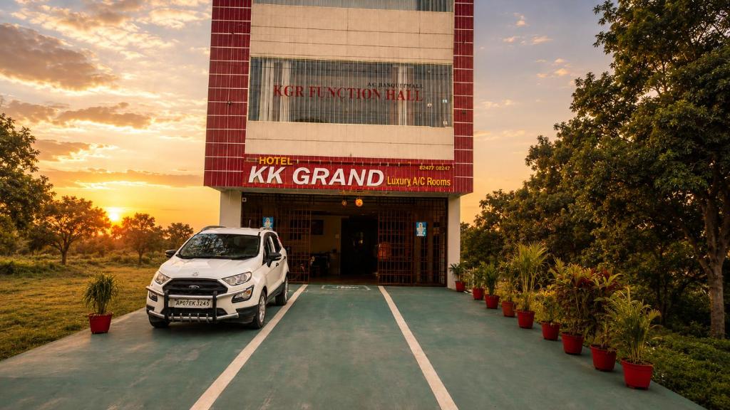 a car parked in a parking lot in front of a building at Hotel KK Grand in Guntūr