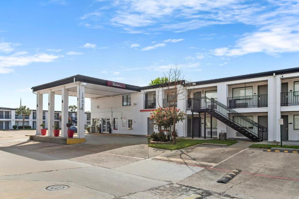 an empty parking lot in front of a building at Red Roof Inn Houston - Jersey Village in Houston