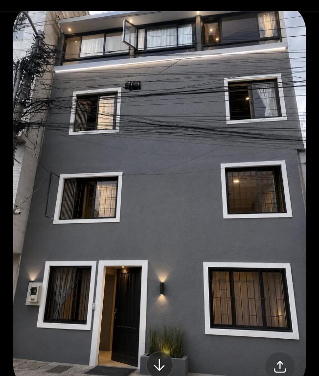 a gray building with windows and a door at Nuevo Hotel Transportador in Bogotá