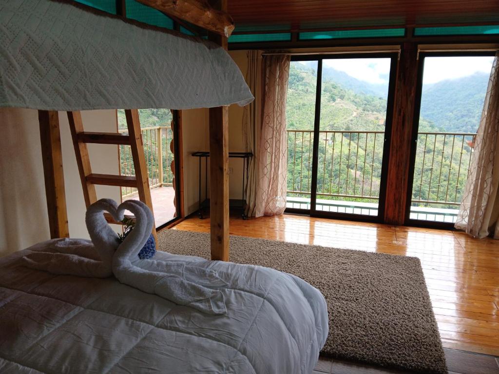 a bedroom with two swans in a bed with a view at Refugio de Paz Providencia in El Copey