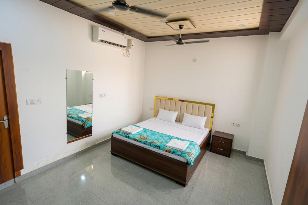 a bedroom with a bed and a mirror at Omji Ashram - Ramnagar 10 min from Shri Banke Bihari Temple in Vrindāvan
