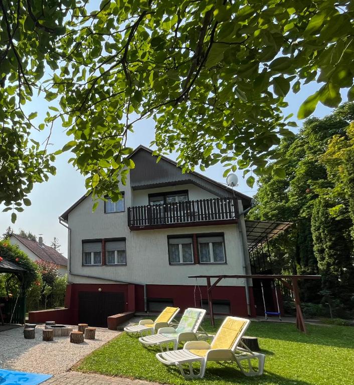 a group of lawn chairs in front of a house at Balatonfölvári nyaraló in Balatonföldvár