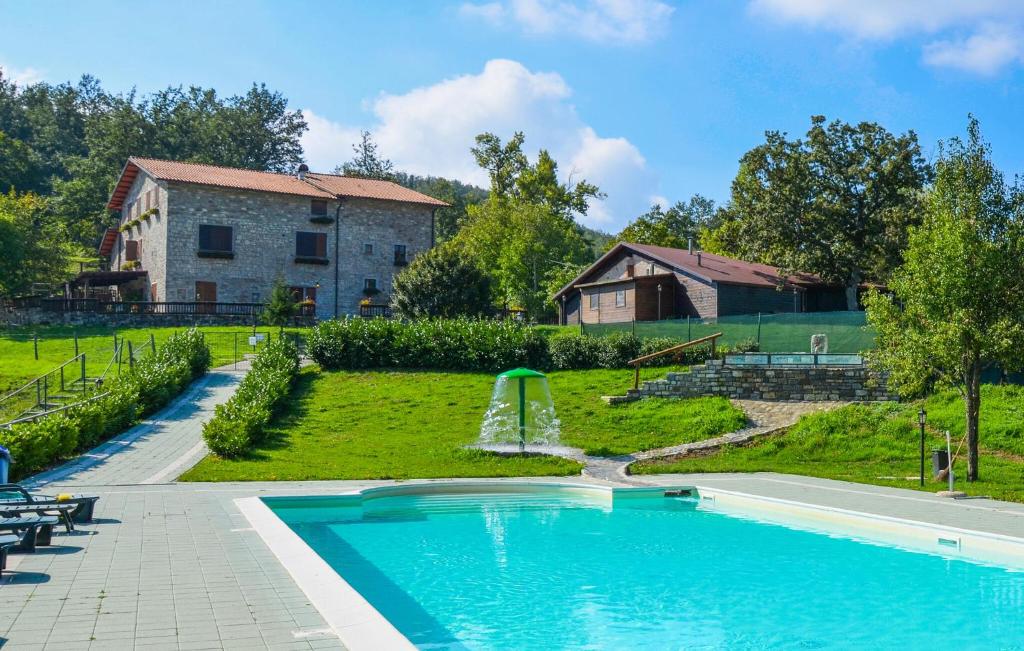 a swimming pool with a fountain in a yard at Oasi Di Cocciola in Badia Tedalda