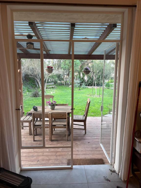 an open door to a patio with a table and chairs at חלום ליד הנחל in ‘Amir