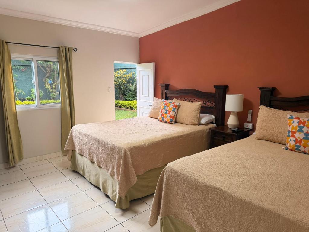 a bedroom with two beds and a window at Inari Guatemala in Guatemala