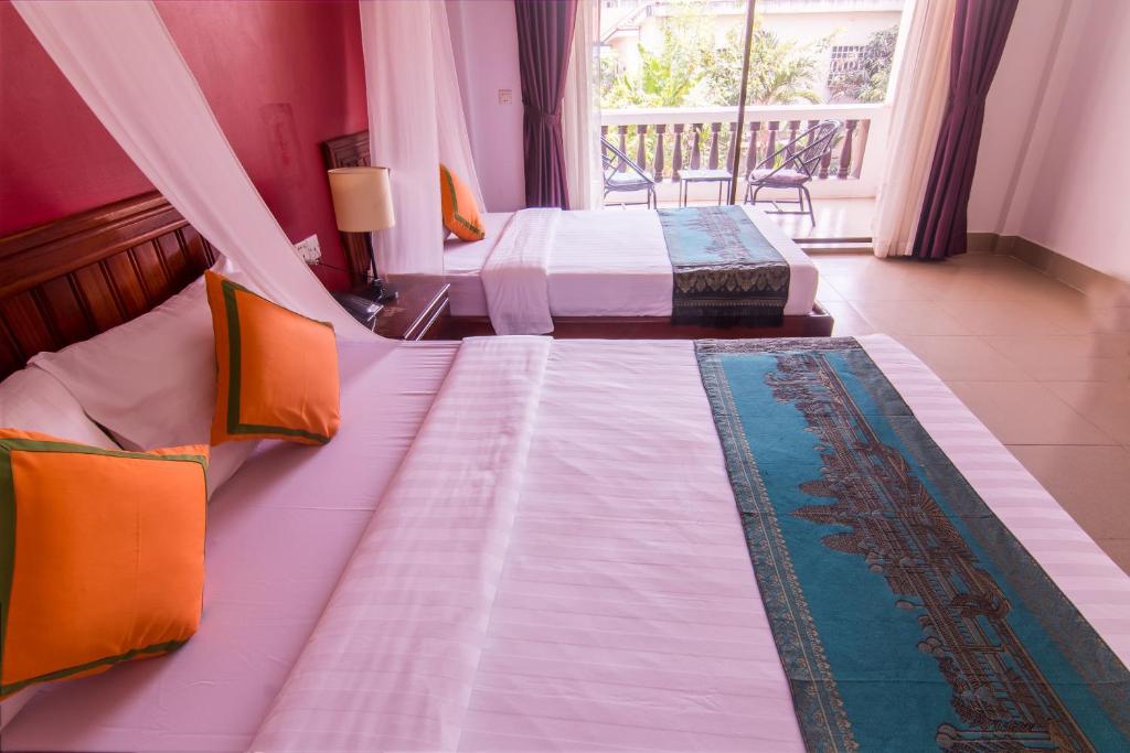 Postel nebo postele na pokoji v ubytování Mekong Angkor Palace Hotel