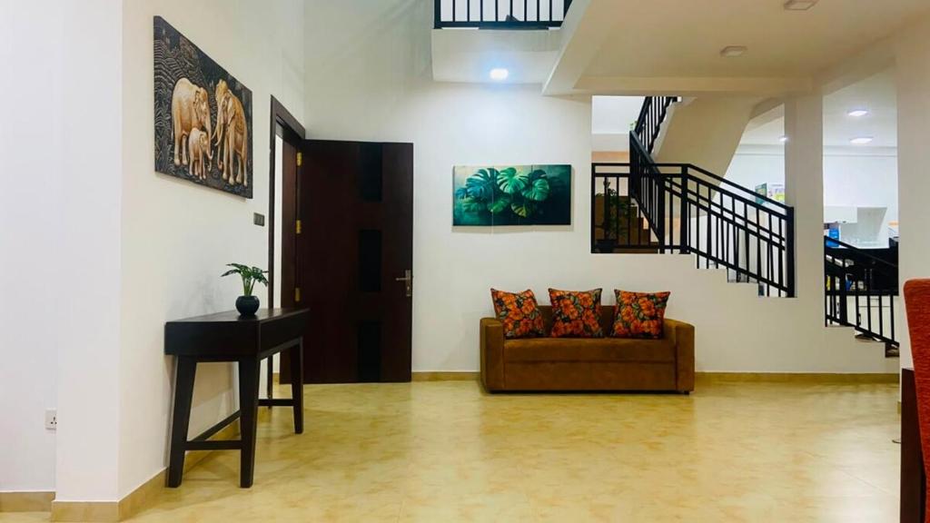 a living room with a couch and a staircase at willow Blossoms in Pannipitiya