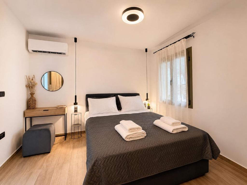 a bedroom with a bed with two towels on it at Elaia & Nyx Residence in Volos