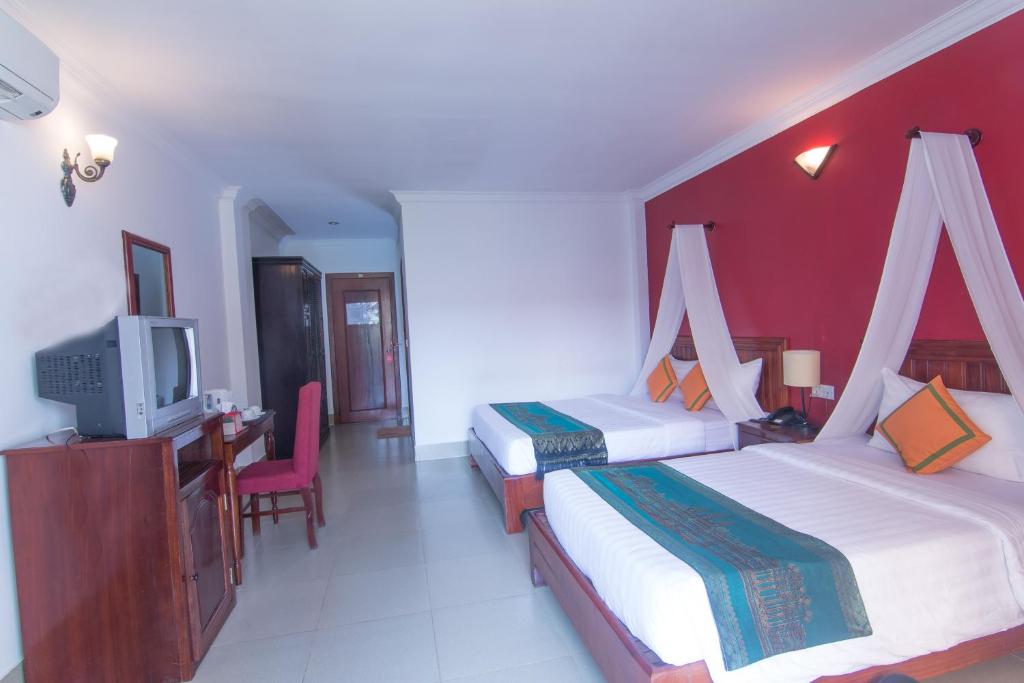 Postel nebo postele na pokoji v ubytování Mekong Angkor Palace Hotel