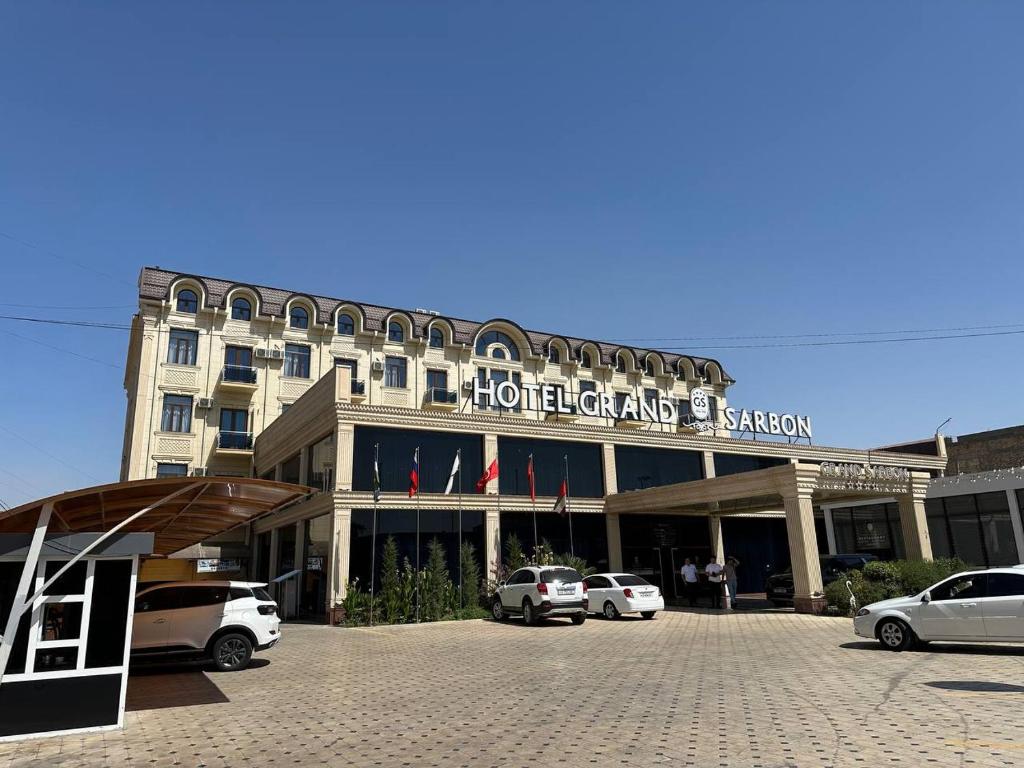 a hotel with cars parked in front of it at GRAND SARBON HOTEL in Qarshi