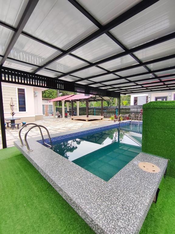 an outdoor swimming pool with a patio and a building at Private Pool Homestay Kota Bharu 3 Bilik Tidur Muat 12 Tetamu in Kota Bharu
